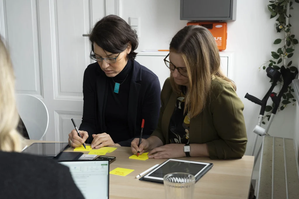 2 Workshop-Teilnehmerinnen beschreiben Post-Its